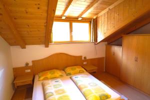 阿皮亚诺苏拉斯特拉达Unterbi Apartments的一间小卧室,配有两张床和窗户