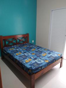 乌巴图巴Praialar Apartamentos Ubatuba的卧室内的一张蓝色棉被