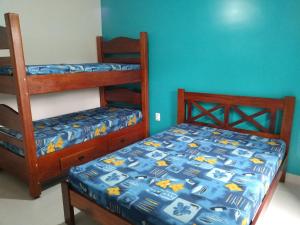 乌巴图巴Praialar Apartamentos Ubatuba的一间卧室设有两张双层床和蓝色的墙壁