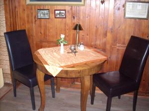 Kluis老学院餐厅旅馆的一张带两把椅子的木桌和花瓶