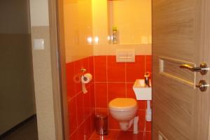 奥古斯图Kwatera Na Rogu的浴室设有卫生间和红色瓷砖。
