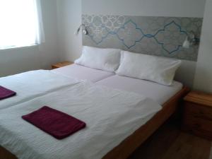 萨尔瓦尔剑锋公寓酒店的一张带白色床单和紫色毛巾的床