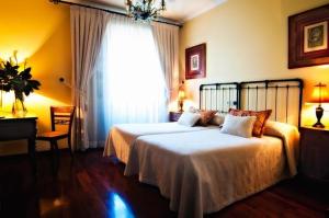 坎巴多斯帕左卡皮塔纳住宿加早餐旅馆的一间卧室设有两张床和大窗户