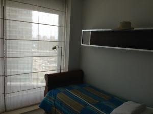 埃斯特角城Apartamento 907的一间卧室设有窗户和一张带毯子的床