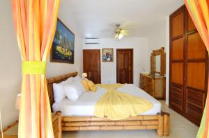 蓬塔卡纳La Flor del Caribe Beach & SPA的一间卧室配有一张带橙色窗帘的床