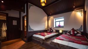大理大理喜林苑 · 杨品相宅的一间卧室设有两张床和窗户。
