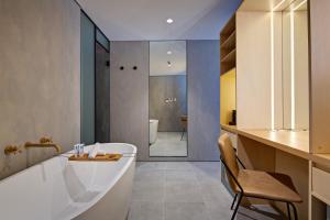 悉尼扎拉大厦 - 豪华套房和公寓 的带浴缸和椅子的浴室