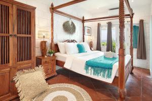 乌鲁瓦图克让宾海滩别墅的一间卧室配有一张天蓬床和一把椅子