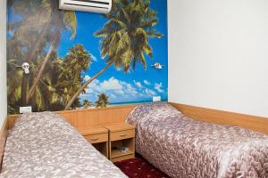 斯塔夫罗波尔帕利提亚旅馆的一间设有两张床的客房,并拥有棕榈树的壁画