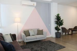 曼谷Airee Premier Residence的带沙发和粉红色墙壁的客厅