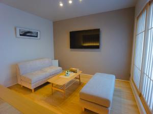 福冈GRAND BASE Hakata Sumiyoshi的客厅配有沙发和桌子