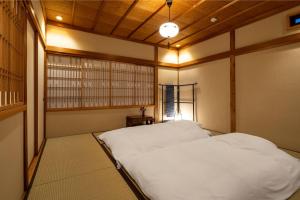 金泽Kurohoro Machiya House的卧室配有白色的床