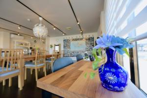 伊势市Ise Guest House Sora的花朵坐在桌子上的蓝色花瓶