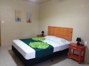 MulifanuaTransit Motel的一间卧室配有一张带绿色床单的大床