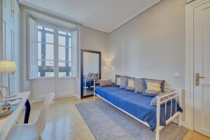 潘普洛纳Pensión Mendi的客厅设有蓝色的沙发和窗户。