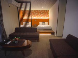 福冈GRAND BASE Hakata Sumiyoshi的客厅配有沙发和1张床
