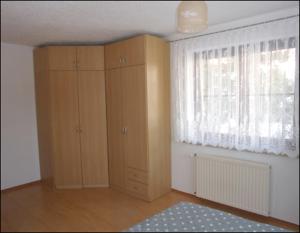 Kohren-SahlisFerienwohnung Kohrener Land的客房设有木制橱柜、窗户和地毯。