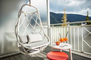 达沃斯达沃斯硬石酒店的阳台配有秋千椅和桌子