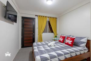 美岸Happy Grey Hotel Vigan的一间卧室配有红色和白色枕头的床