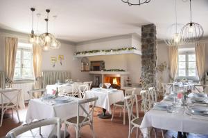 坎塔格里罗Villa Zelma的一间设有白色桌椅和壁炉的用餐室