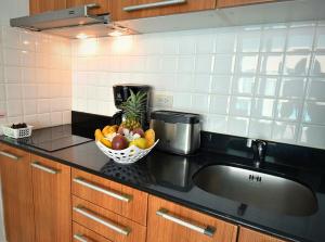 高兰Sai Naam Lanta Residence SHA Plus的厨房柜台设有水槽和一碗水果
