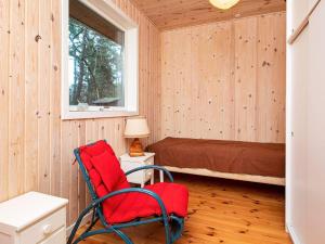 弗雷德里克斯伐克8 person holiday home in Frederiksv rk的一间设有红色椅子和一张床的房间