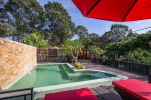 暹粒De Sarann Villa的庭院内一个带遮阳伞的游泳池