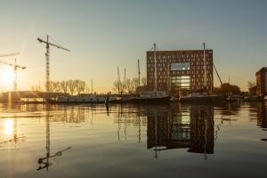 阿姆斯特丹the niu Fender的享有河流美景,设有一座建筑和起重机