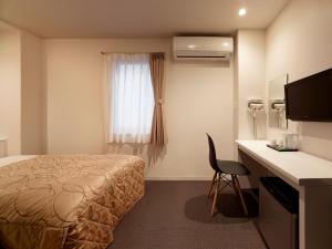 东京新东北酒店的配有一张床、一张书桌和一扇窗户的酒店客房