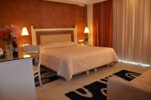 帕莱欧卡斯提撒奥德修斯酒店的一间卧室配有一张床、一张桌子和一张沙发