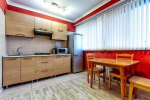 阿拉木图420 Апартаменты в центре возле Арбата Отлично подходят для командированных и туристов的厨房配有木桌和冰箱。