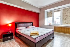 阿拉木图420 Апартаменты в центре возле Арбата Отлично подходят для командированных и туристов的红色的卧室,配有一张床和红色的墙壁