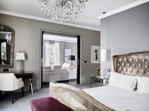开普敦Queen Victoria Hotel by NEWMARK的一间卧室配有一张床和一个吊灯