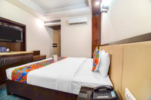 新德里FabHotel Marble Arch的酒店客房配有一张床和电话