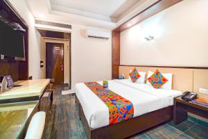 新德里FabHotel Marble Arch的配有一张床和一张书桌的酒店客房