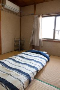 田边市TSUKASA HOUSE English OK Kumano Kodo experience Lodge Close to station 無料駐車場あり的窗户客房内的一张大床