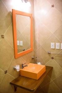 波萨达斯AVEMAR Apart Hotel的一间带水槽和镜子的浴室