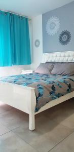 海法Artichoke Boutique的白色的床,带蓝色窗帘的房间