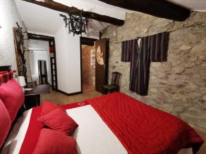 圣皮埃尔德日瓦Logis Hotel Restaurant LA BARGUILLERE的卧室设有红色和白色的床和石墙