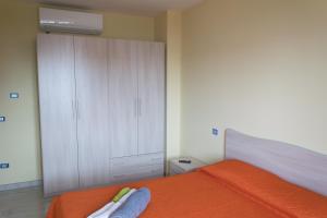 维博瓦伦蒂亚Stella d'Oro的一间卧室配有橙色的床和白色橱柜