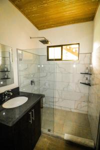 曼努埃尔安东尼奥Teva Hotel & Jungle Reserve的一间带水槽和玻璃淋浴的浴室