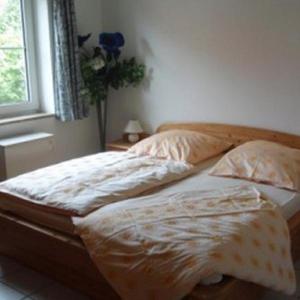 万肯多夫Ferienwohnung-Kapitaens-Kajuete的卧室内的一张未铺好的床,设有窗户