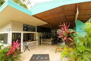 曼努埃尔安东尼奥Teva Hotel & Jungle Reserve的户外庭院,设有遮阳篷、桌子和植物