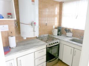 马德普拉塔Cabo Corrientes Center的厨房配有炉灶和水槽