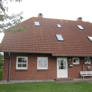 彼得多夫奥费马Ferienwohnung-Achtern-Diek的红砖房子,屋顶有窗户