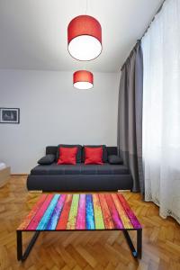 维也纳施塔特哈勒 - 家庭城市公寓的客厅配有沙发和色彩缤纷的地毯