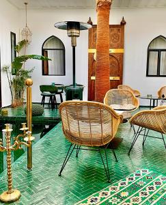 马拉喀什Riad Dar Yasaman的一间设有藤椅和玻璃桌的房间