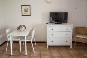 桑塔纳Casas de Campo do Pomar B&B - Self Check-in的一张带电视和梳妆台的白色餐桌