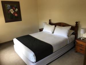 仙女港Seacombe House Motor Inn Port Fairy的卧室配有一张带白色床单和枕头的大床。