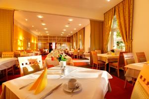 维也纳阿尔特多瑙河海滩酒店的用餐室配有白色桌椅和桌子。